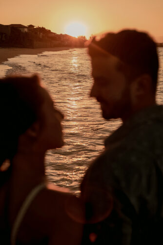 Ensaio pre-wedding na praia com casal ao pôr do sol